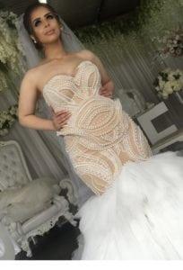Fitted plus size wedding dress made with pearls in nude color from Darius Bridal